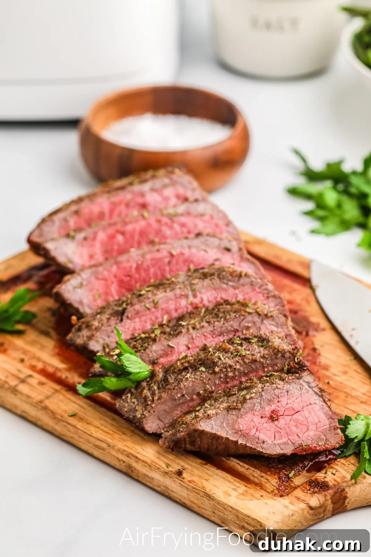 Seasoned and sliced Air Fryer London Broil on a cutting board.