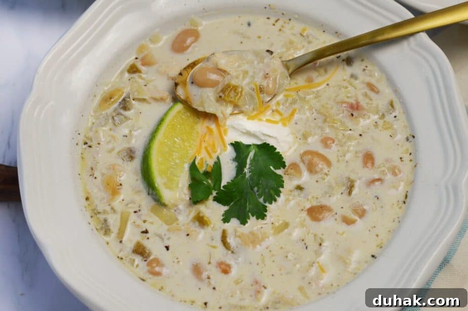 Creamy White Chicken Chili Recipe — Hearty Crockpot & Stovetop Options 5 one white bowl filled with white chicken chili