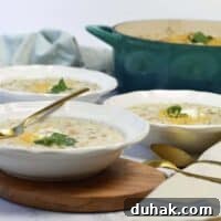 3 white bowls of white chicken chili with gold spoons