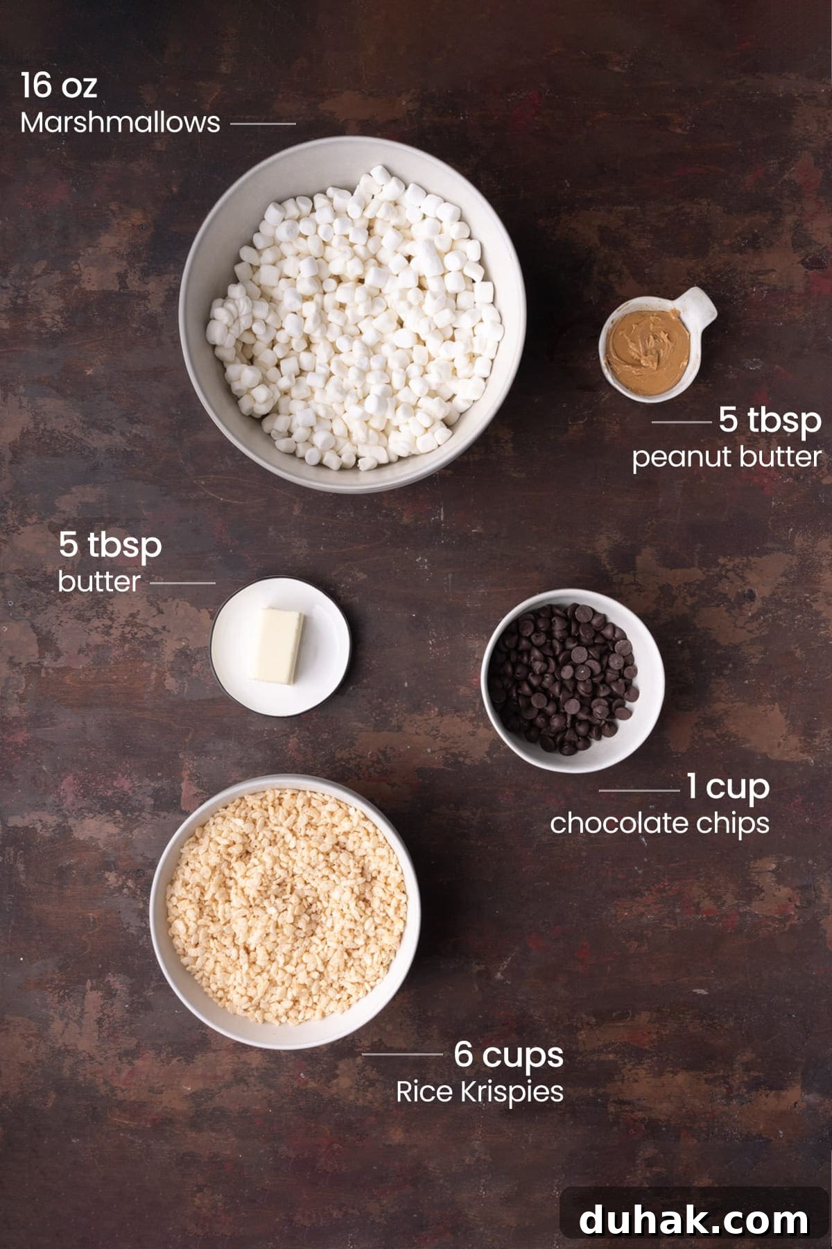 Overhead view of all the ingredients for Chocolate Peanut Butter Rice Krispies Treats - marshmallows, peanut butter, butter, chocolate chips, and Rice Krispies.