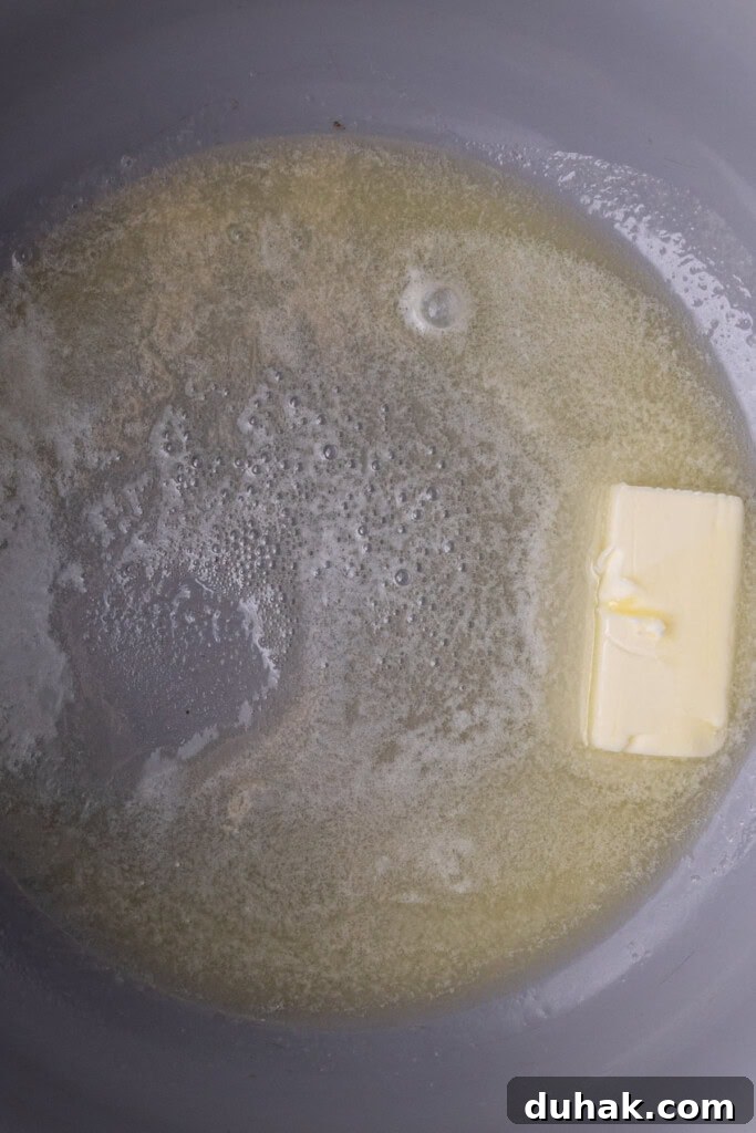 Butter melting in a large pot before adding peanut butter and marshmallows.