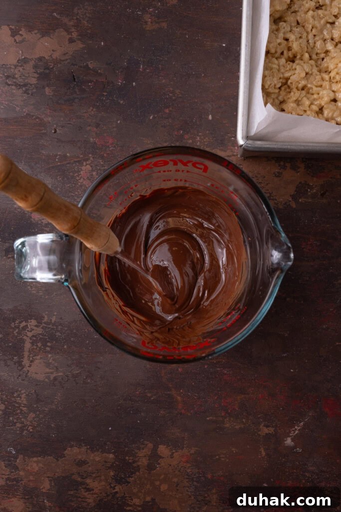 Melted chocolate in a glass measuring cup, mixed until smooth with a fork.