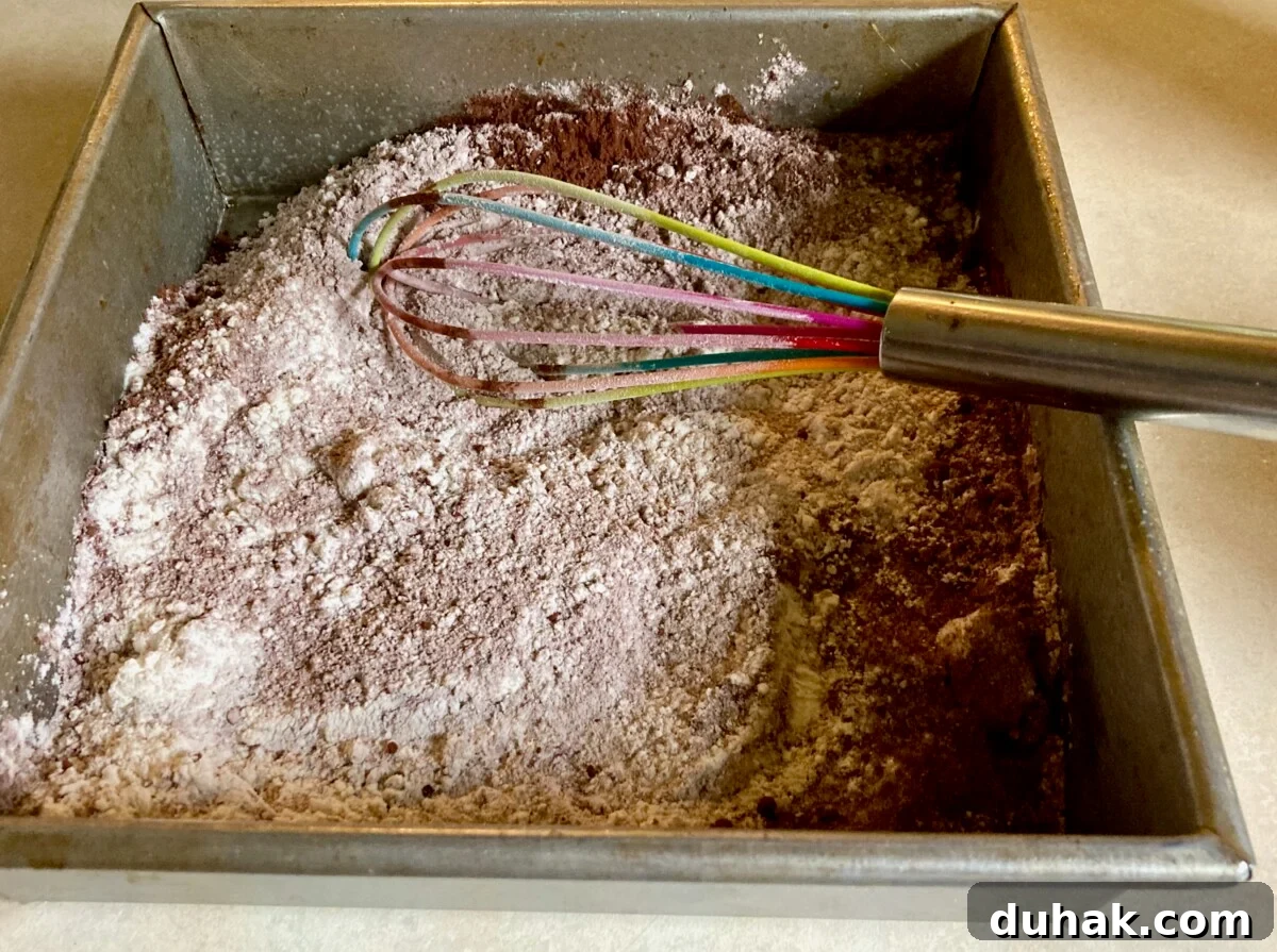 Eggless Wacky Cake Recipe — No Butter, No Milk Needed 4 Whisking together cake ingredients.