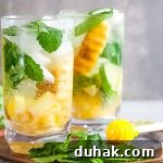 2 glasses of Grilled Pineapple Mojitos with mint and honey