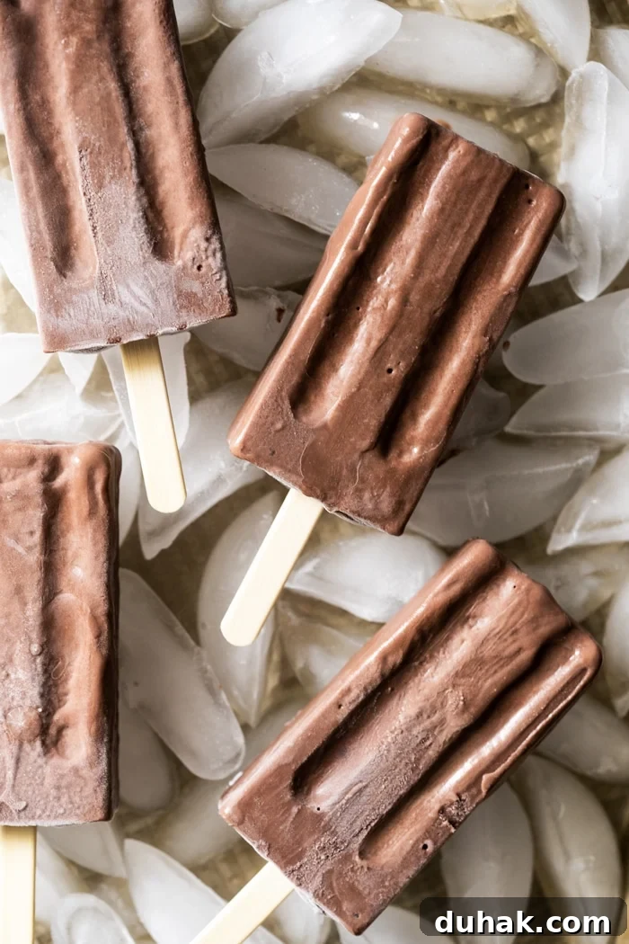 Freshly unfolded chocolate popsicles on a bed of ice