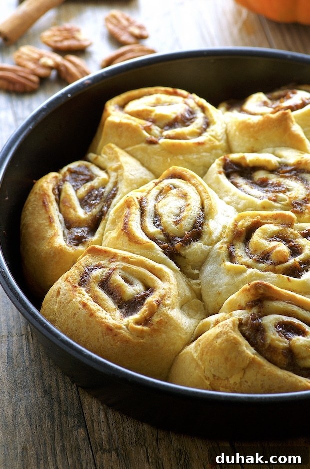 Maple-Banana Pumpkin Cinnamon Rolls with Warm Cinnamon Glaze 10 Side partial view of a pan of cinnamon rolls
