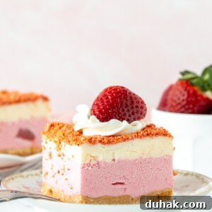 Slice of strawberry shortcake ice cream cake with whipped cream and a strawberry on top