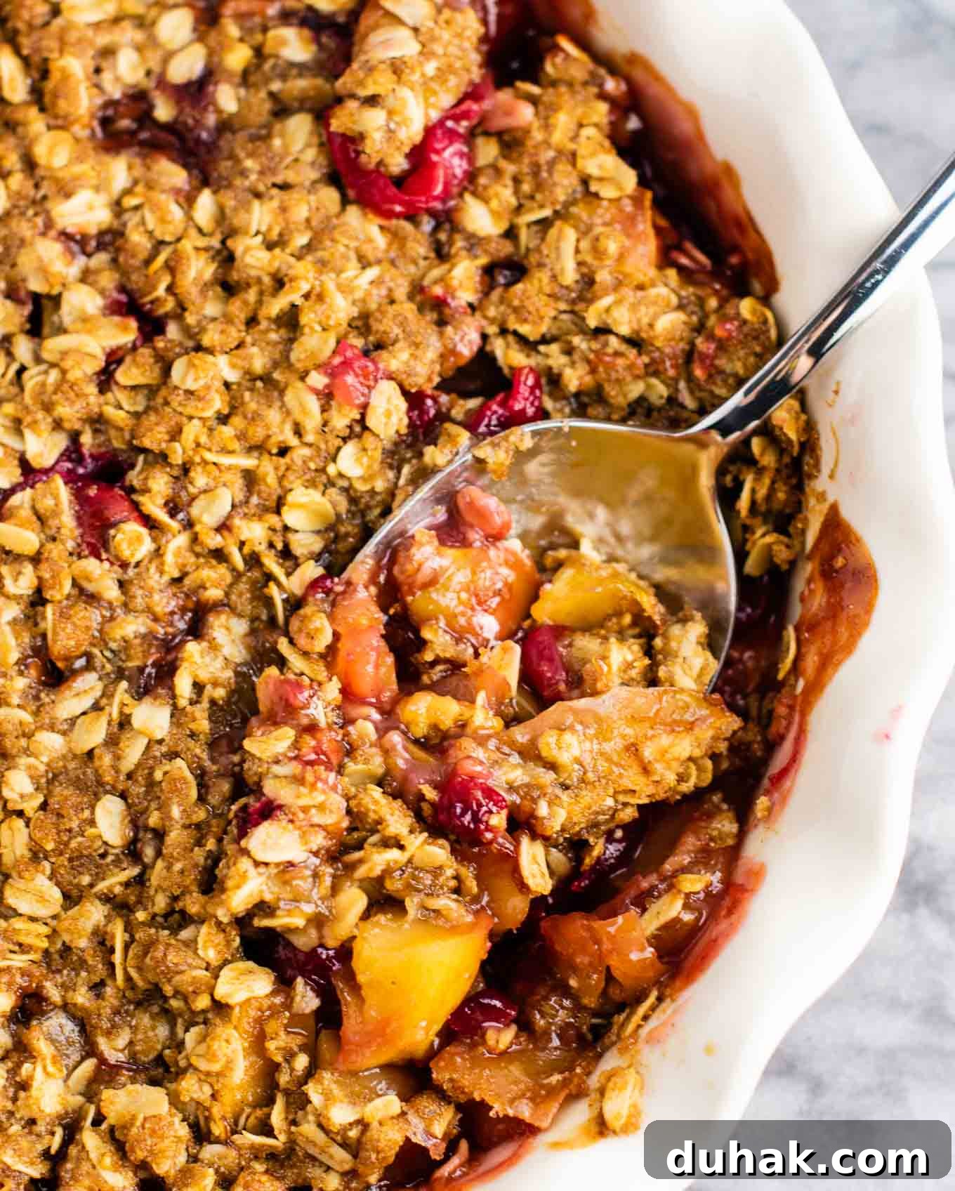 Cranberry Apple Crisp with Warm Cinnamon Crumble 6 taking a spoon of cranberry apple crisp