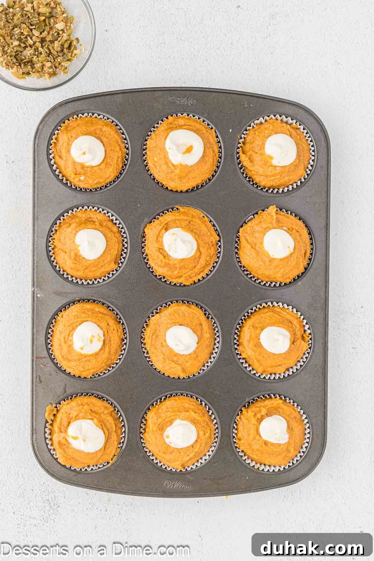 Cream cheese filling dolloped in the center of each muffin. 