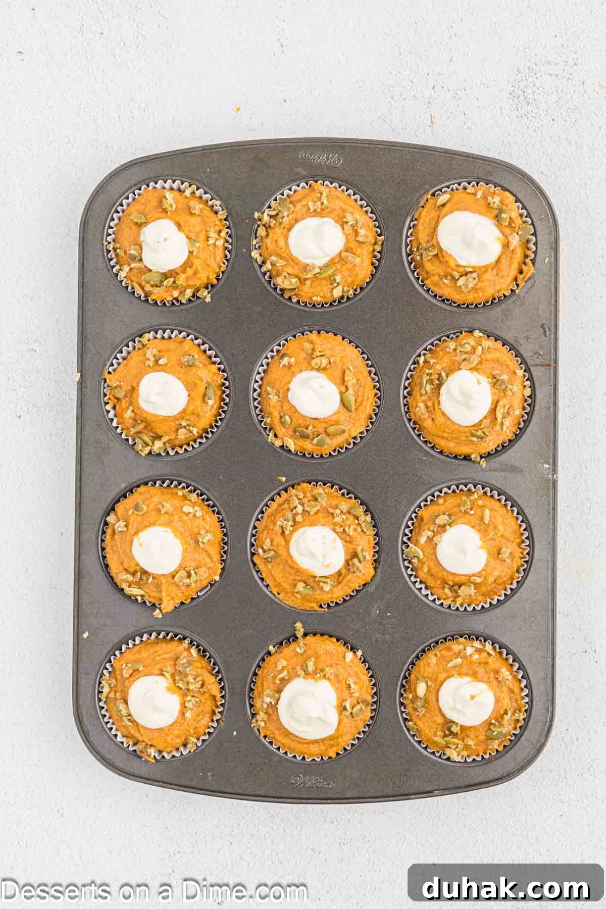 Pumpkin seeds sprinkled on each muffin. 