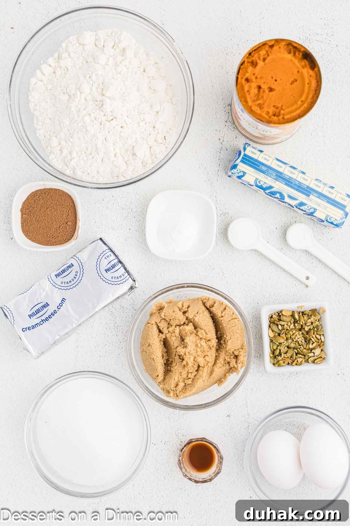 Ingredients for Pumpkin Muffins - flour, pumpkin pie spice, baking soda, brown sugar, eggs, pumpkin puree, butter, cream cheese, vanilla, butter, pumpkin seeds. 