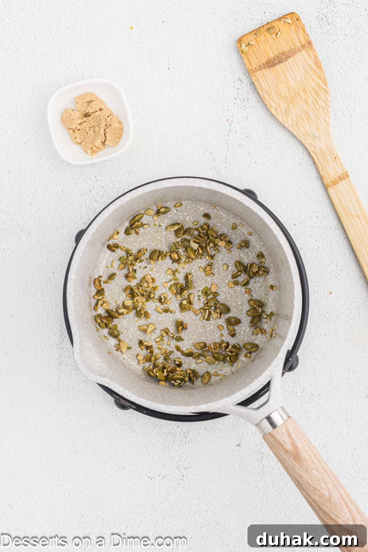 Pumpkin seeds in a saucepan with butter. 
