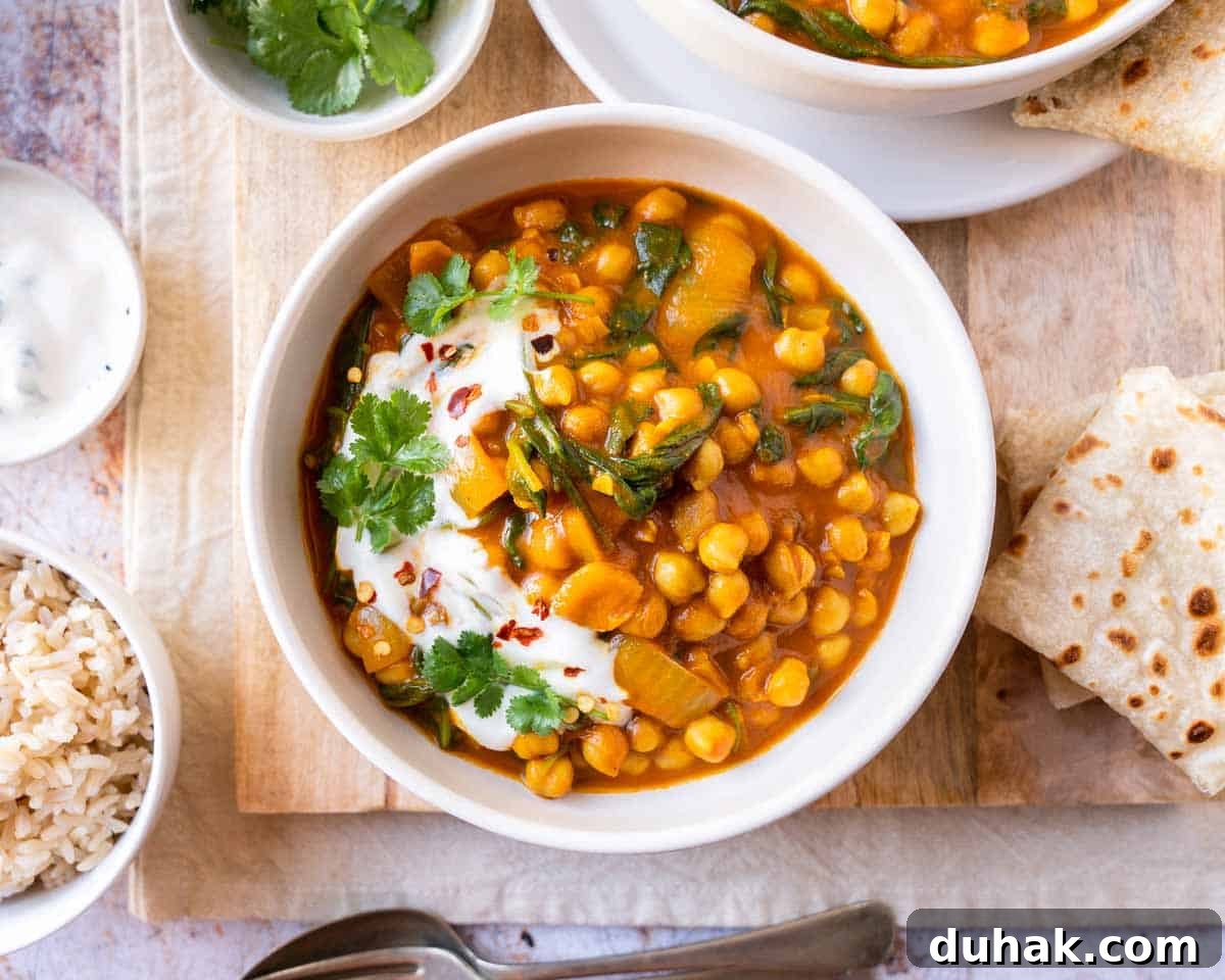 Chickpea and spinach curry garnished with fresh cilantro and yogurt.