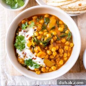 Chickpea and spinach curry garnished with fresh cilantro and yogurt.