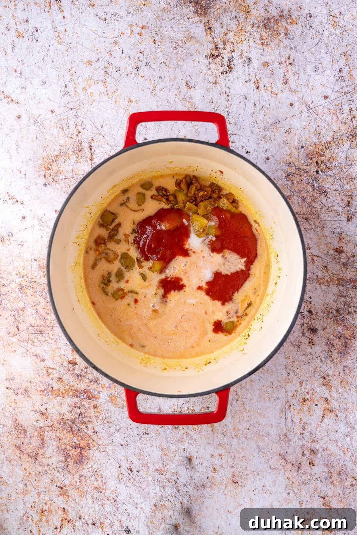 Coconut milk and tomato sauce added to curry mixture.