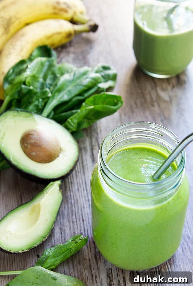 Refreshing Nutrient-Packed Green Smoothie Recipe for Energy 4 Green smoothie next to avocado spinach and bananas.