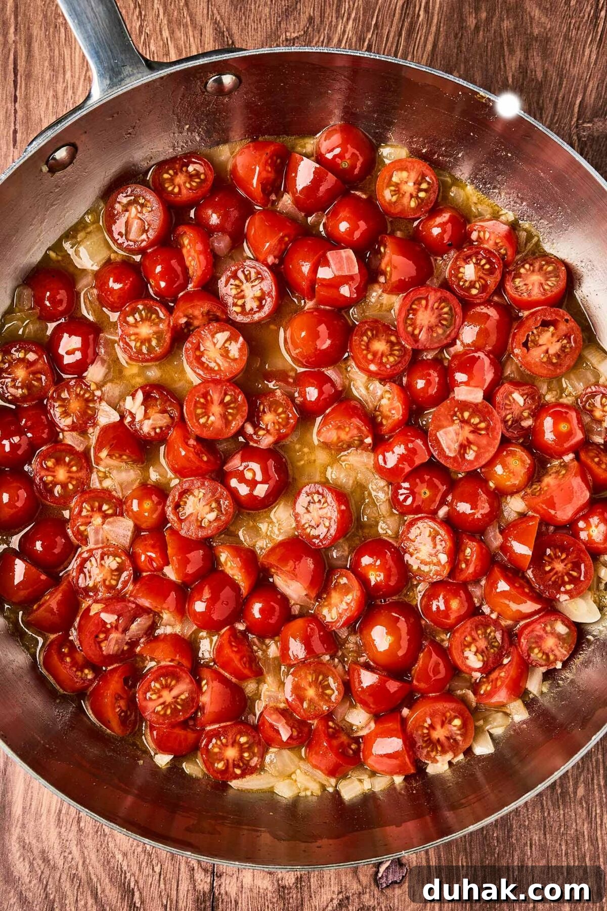 Creamy Goat Cheese Pasta with Fresh Cherry Tomatoes 5 Cherry tomatoes softening with sautéed onion, garlic, and broth for goat cheese pasta with fresh tomatoes.