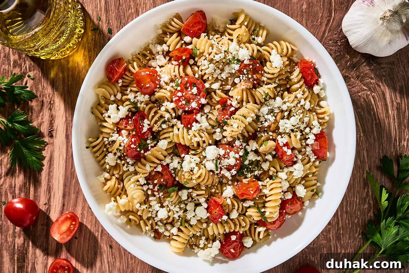Creamy Goat Cheese Pasta with Fresh Cherry Tomatoes 6 Goat cheese pasta with fresh tomatoes, rotini, toasted pine nuts, and parsley in a white pasta bowl.