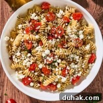 Creamy Goat Cheese Pasta with Fresh Cherry Tomatoes 7 Goat cheese pasta with fresh tomatoes, rotini, toasted pine nuts, and parsley in a white serving bowl.