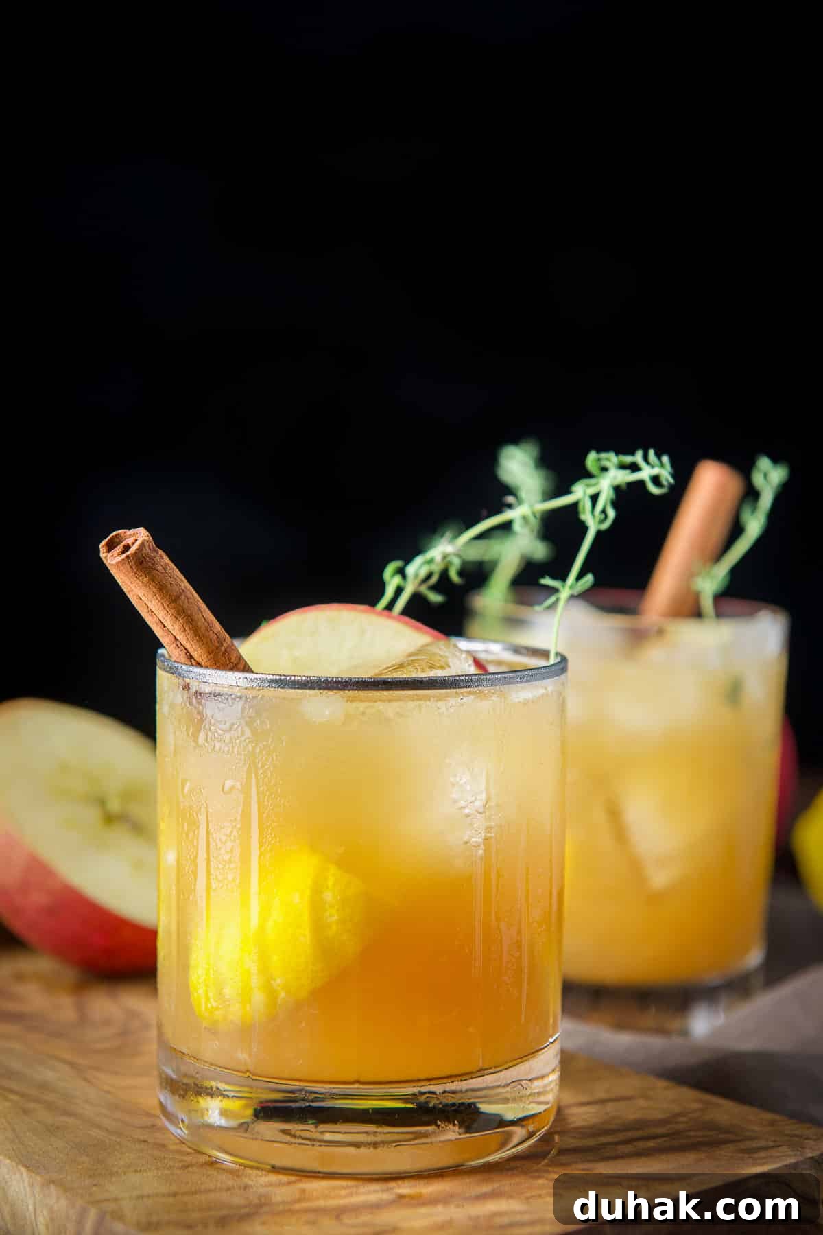 Apple Cider Bourbon Smash Cocktail Recipe 2 Vertical view of the beveled glass with the bourbon smash with cinnamon, apple and thyme