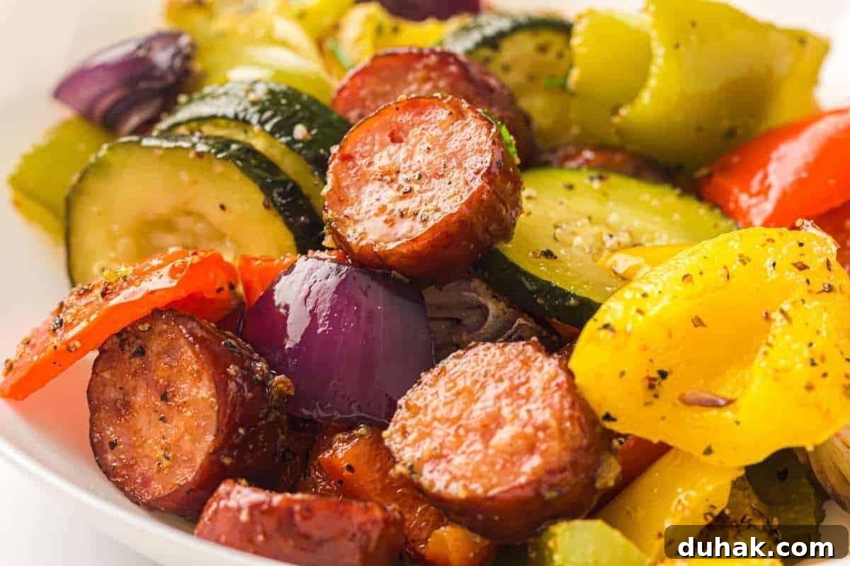 37 Comfort Food Recipes That Keep Reappearing on Menus 34 Sliced sausage, zucchini, red onion, yellow and red bell peppers seasoned with pepper and herbs on a white plate.