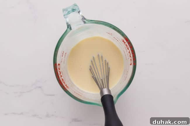 Whisking milk and egg in a measuring pitcher.
