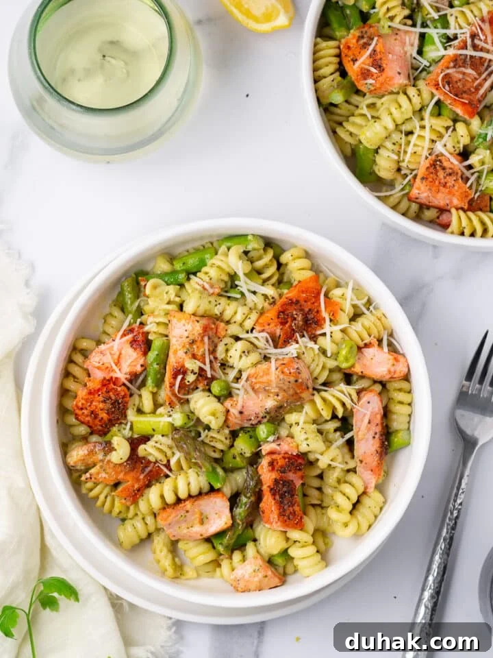 Creamy Salmon Pesto Pasta with Lemon Zest 2 two white bowls with pesto pasta, salmon, asparagus and peas