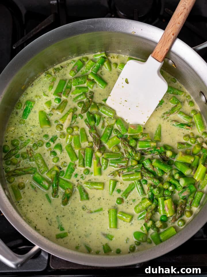 Creamy Salmon Pesto Pasta with Lemon Zest 12 stirring mixture with a wooden spatula