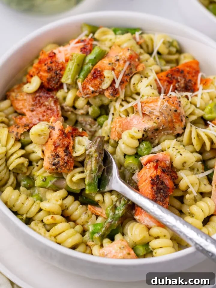 Creamy Salmon Pesto Pasta with Lemon Zest 19 bite of asparagus, salmon and pesto pasta on a fork