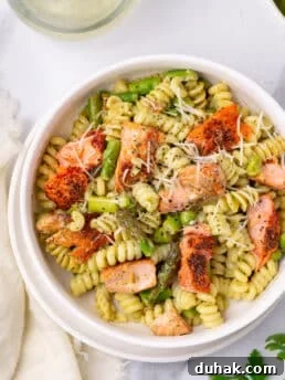 white bowl with salmon pesto pasta with peas and asparagus