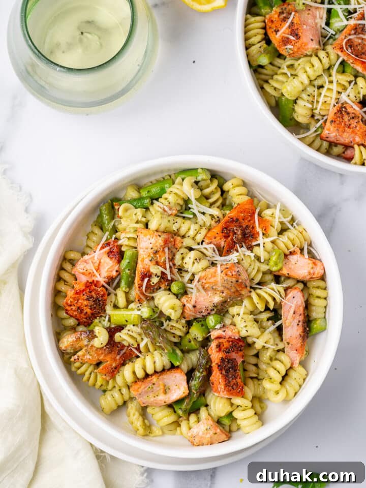 Creamy Salmon Pesto Pasta with Lemon Zest 5 white bowl with pesto pasta and salmon, glass of wine