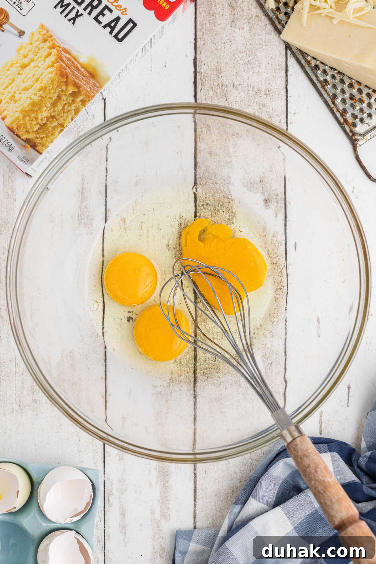 Eggs broken into a mixing bowl, about to be beaten.