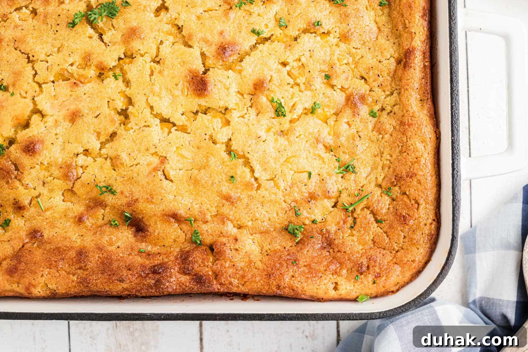 Overhead shot of a dish full of cornbread pudding, just the corner photographed.