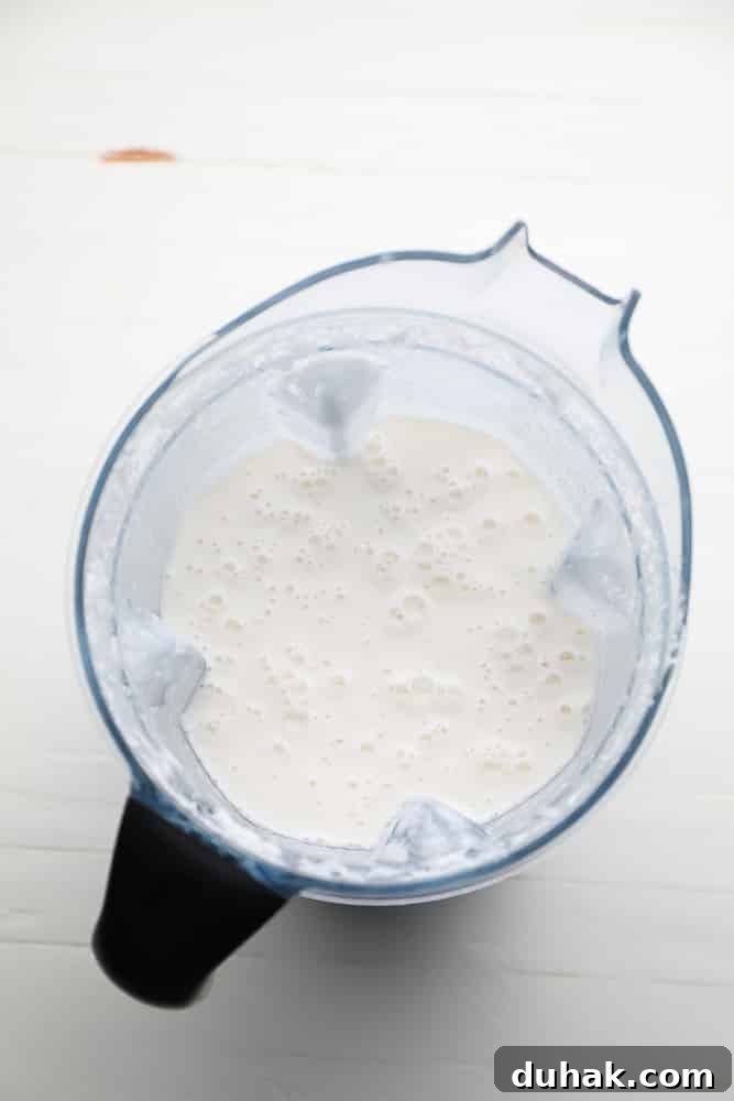 blender full of creamy mixture with bubbles on top