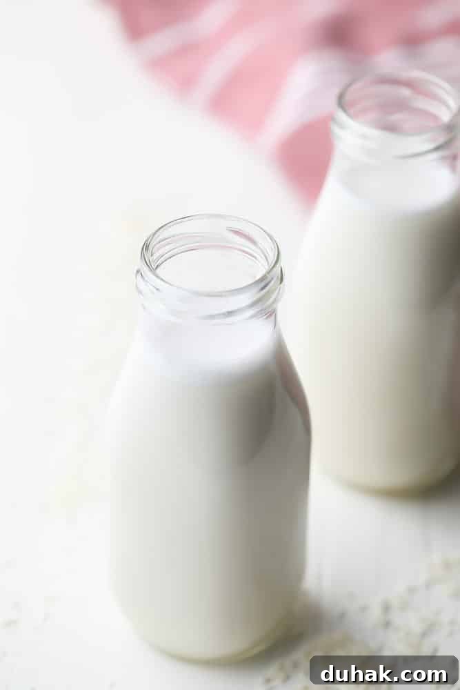 two bottles of creamy milk with coconut shreds all around