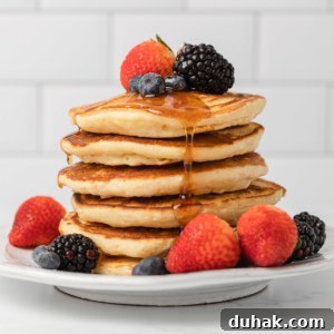 stack of evaporated milk pancakes with fresh fruit and syrup