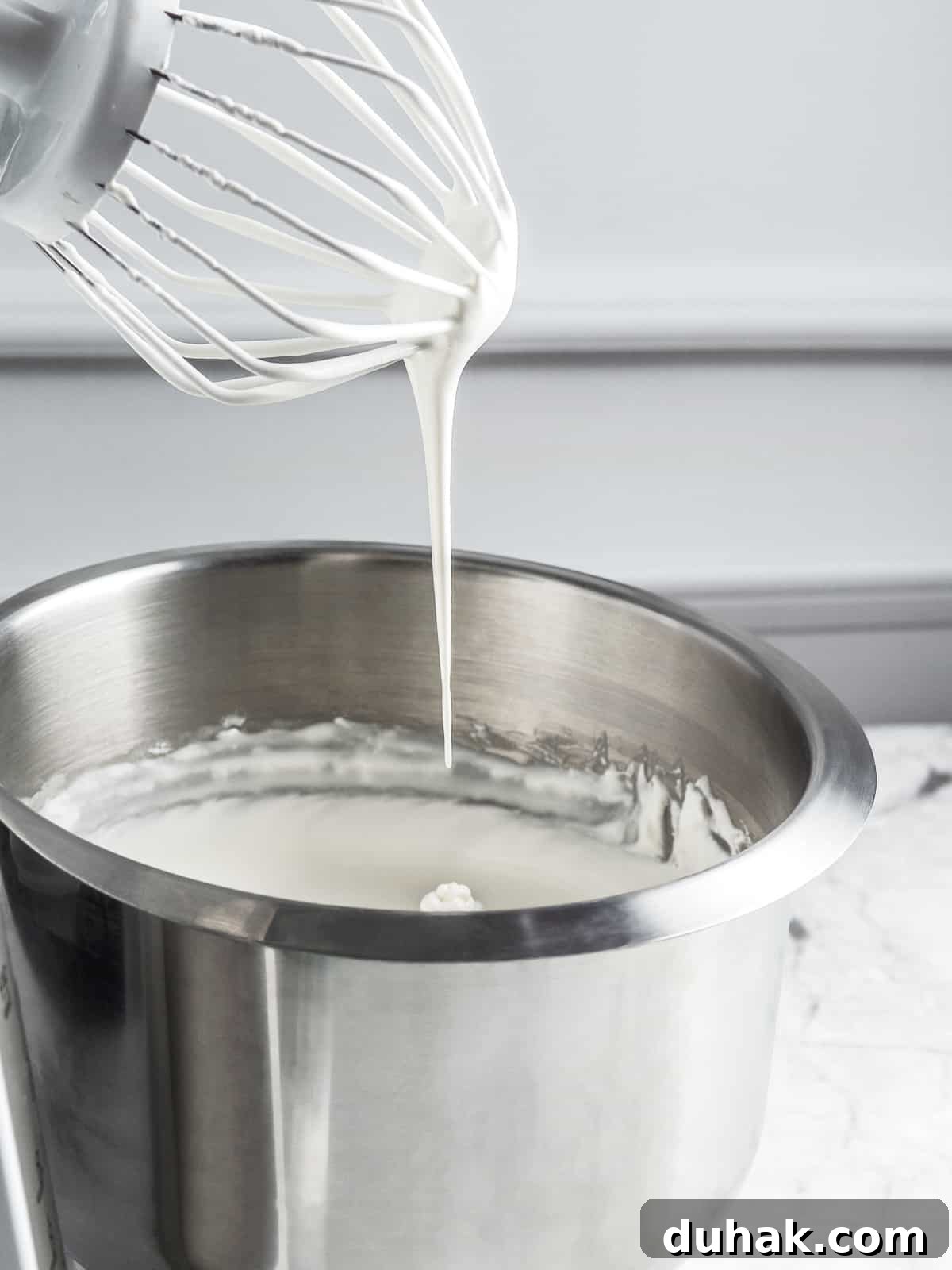 Chantilly cream with a soft peak at the tip of the whisk