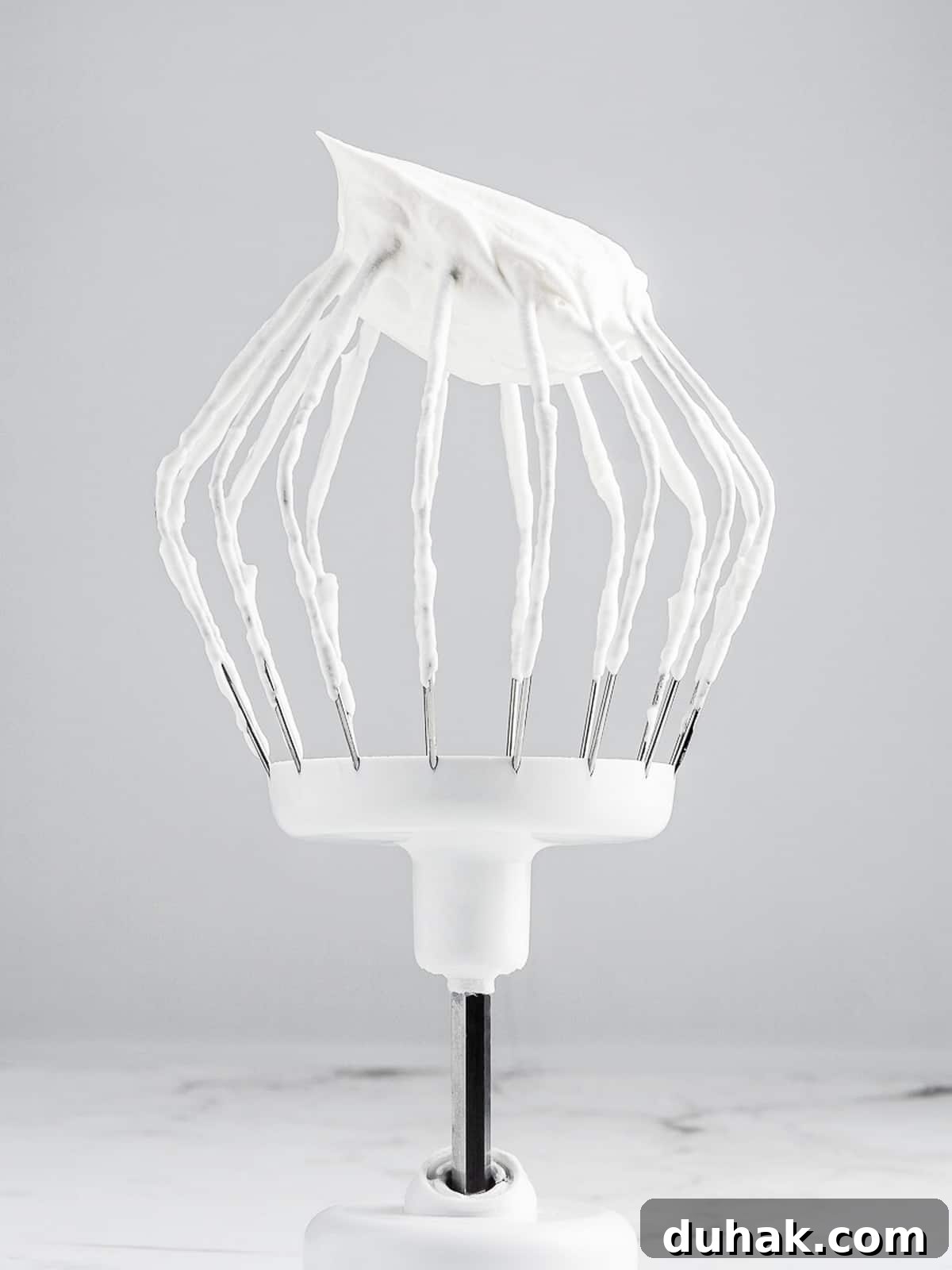 Chantilly cream with a stiff peak on a whisk attachment