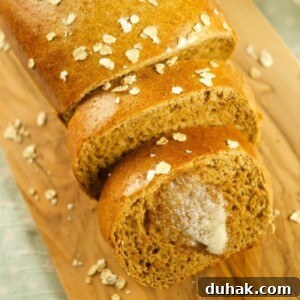 A loaf of brown bread on a wooden board.