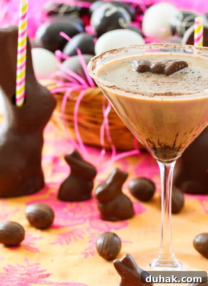 A chocolate martini served in a glass garnished with a mini chocolate bunny.