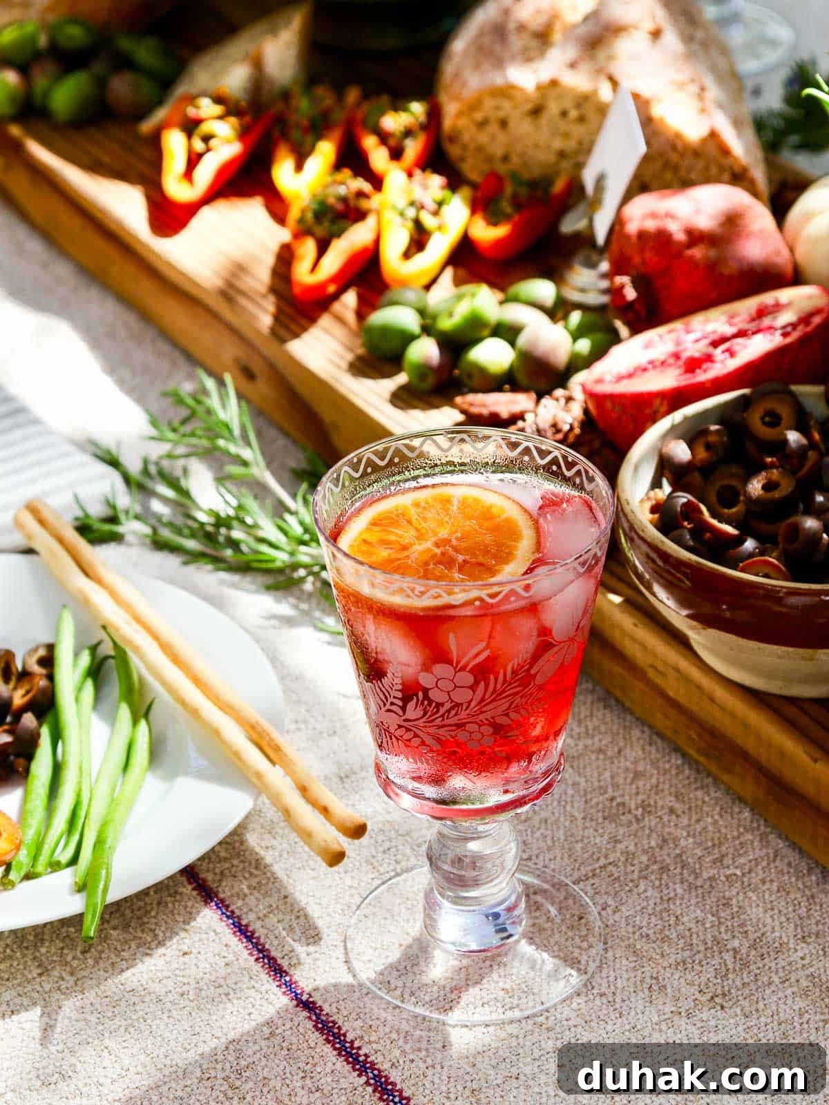 A fancy etched cocktail glass filled with a red hibiscus tea keto cocktail.