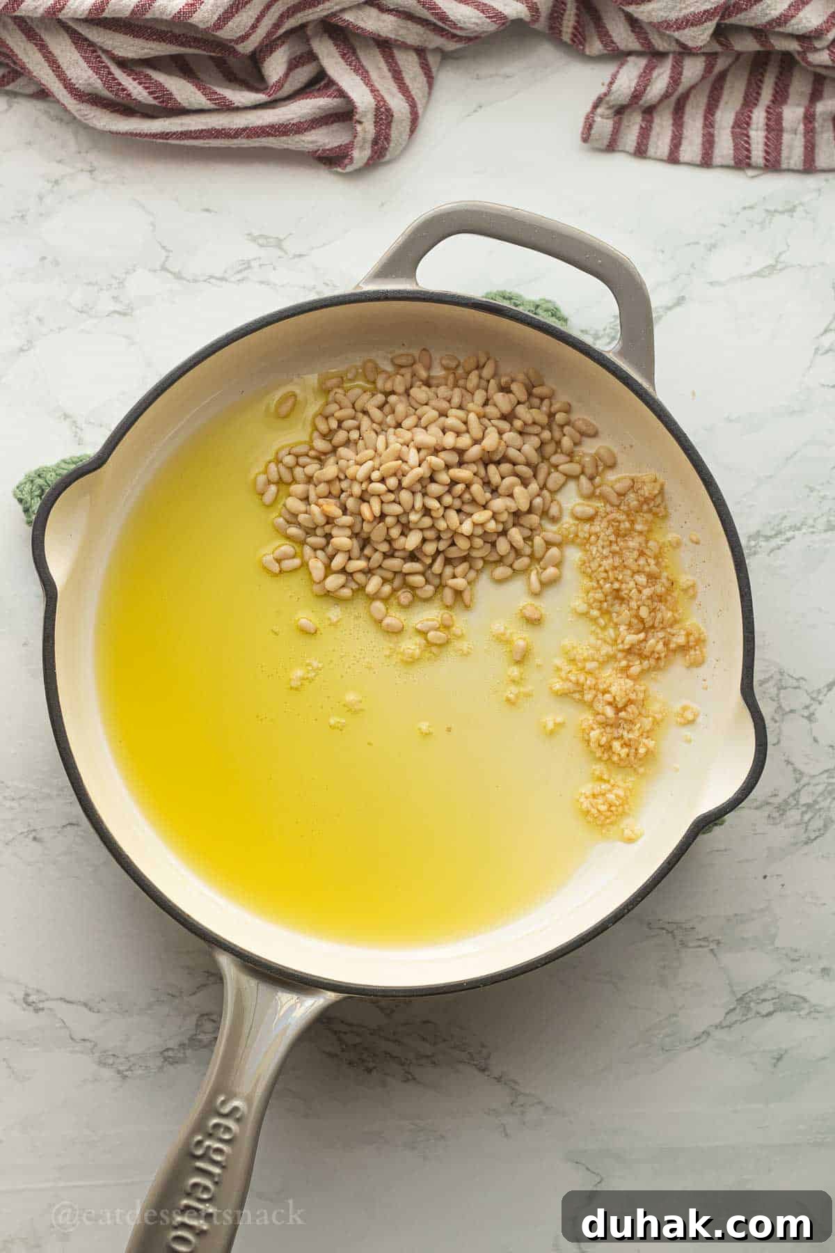 Creamy Ricotta and Butter Bean Salad with Lemon Herb Dressing 5 Pine nuts with garlic in pan with olive oil.