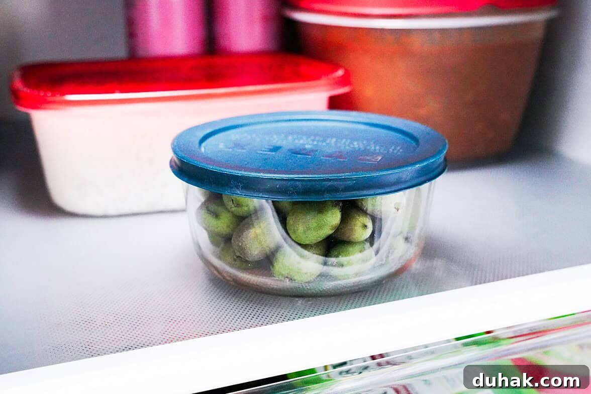 Kiwi Berries: Small Fruit Guide, Taste, Uses, and Benefits 4 Kiwi berries in an airtight container on a fridge shelf