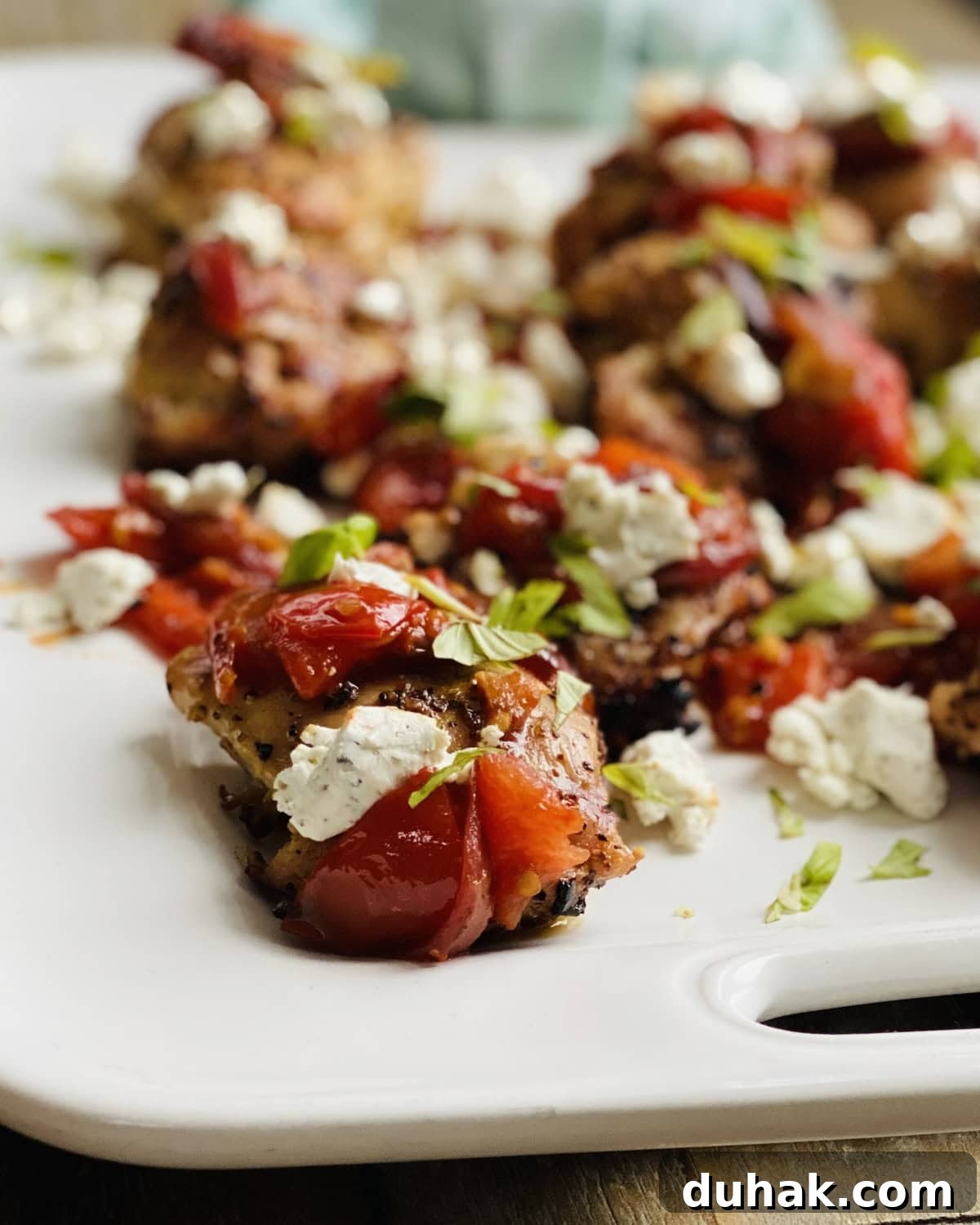 Grilled Chicken with Tomato Bruschetta and Goat Cheese 9 closeup of chicken thigh with bruschetta and goatcheese