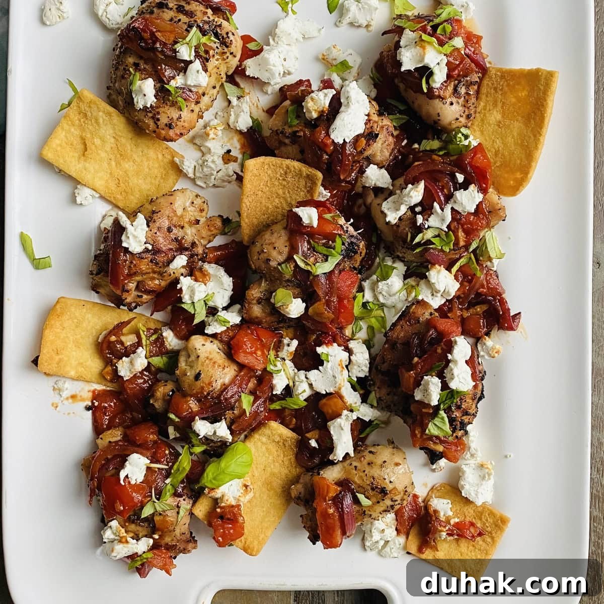 platter of grilled chicken thighs with sautéed bruschetta and goat cheese