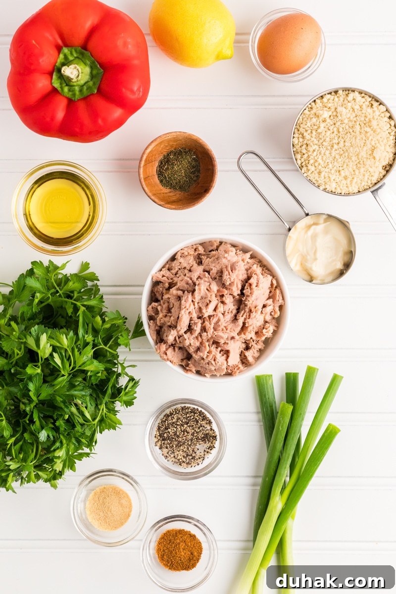 Tuna patties recipe ingredients: canned tuna, mayo, lemon juice, egg, old bay seasoning, black pepper, garlic powder, green onions, red bell pepper, panko bread crumbs and fresh parsley - Hostess At Heart