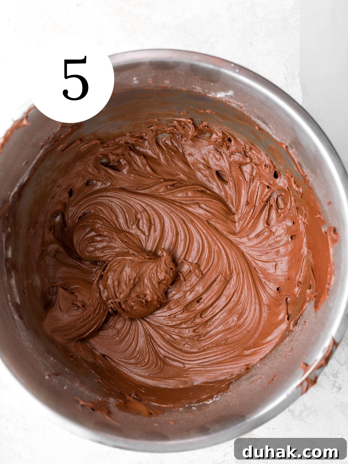 Moist Banana Spice Cake Recipe with Warm Cinnamon Flavor 9 Chocolate frosting in a bowl