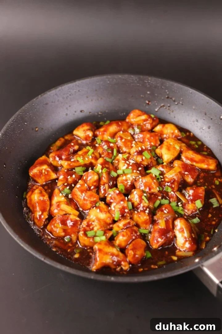 Garlic Chicken Stir-Fry with Spicy Szechuan Sauce 2 Chinese chicken in a black pan with savory garlic sauce.