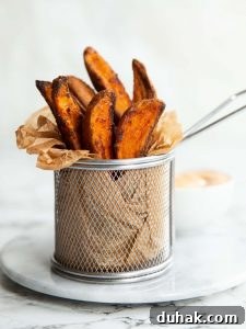 wedges in a small fry container on marble board with dip blurred in background