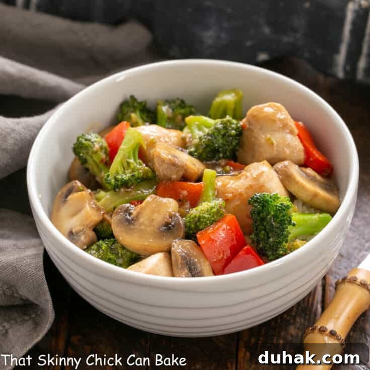 Chicken Broccoli Stir Fry in a white bowl and a bamboo handled fork.